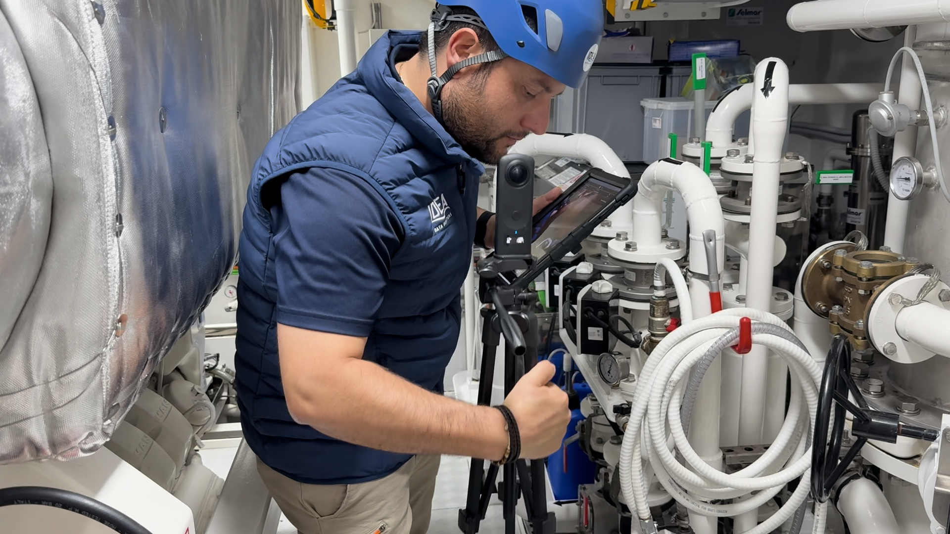Technician documenting engine room systems on a tablet during commissioning